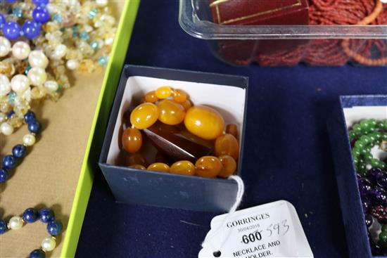 A single strand amber bead necklace, 28grms and an amber cigar holder.